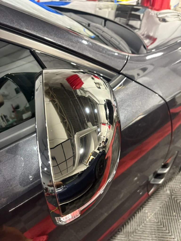 Chrome delete enhances the sleek look of a car's side mirror reflecting its surroundings