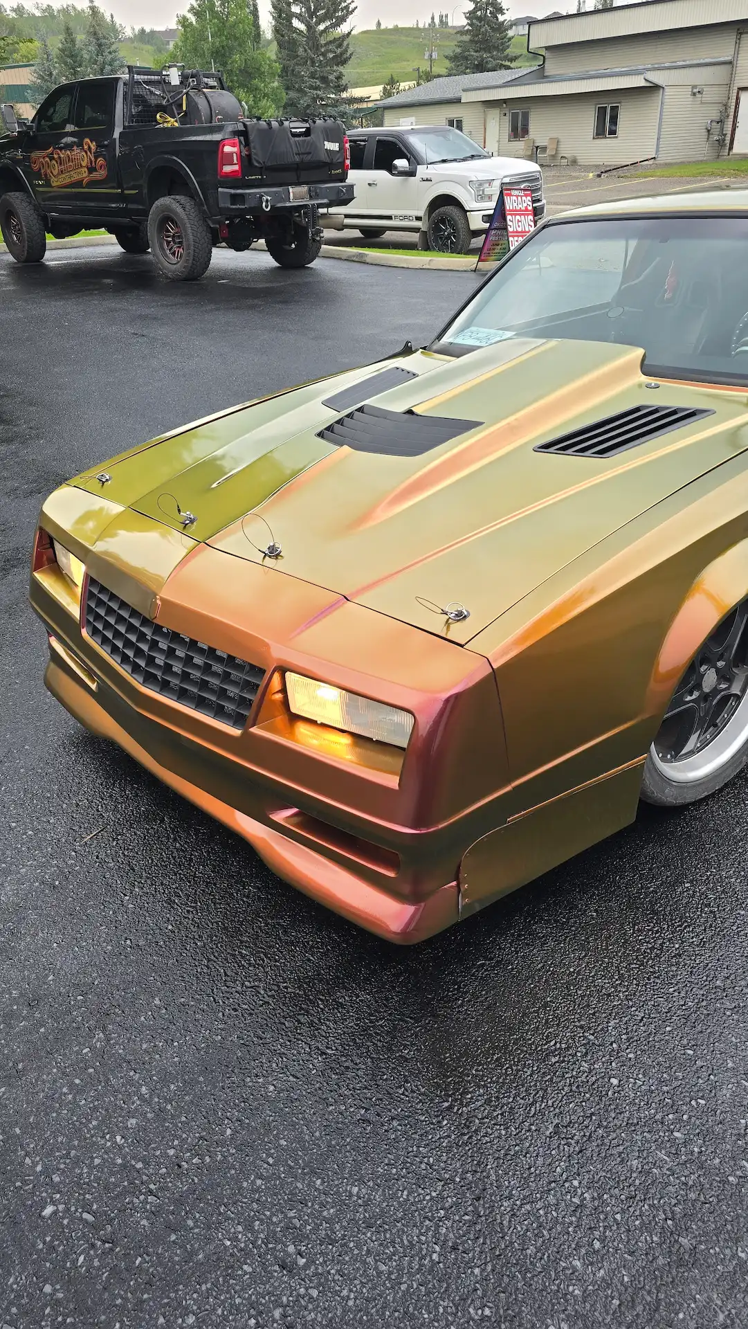 Custom stickers adorn a vividly painted car, glimmering under soft lighting