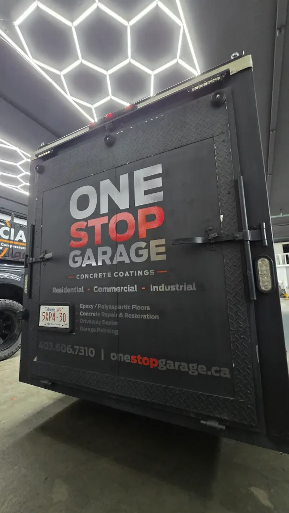 Decals graphics on a trailer showcase a bold logo and garage service contact information